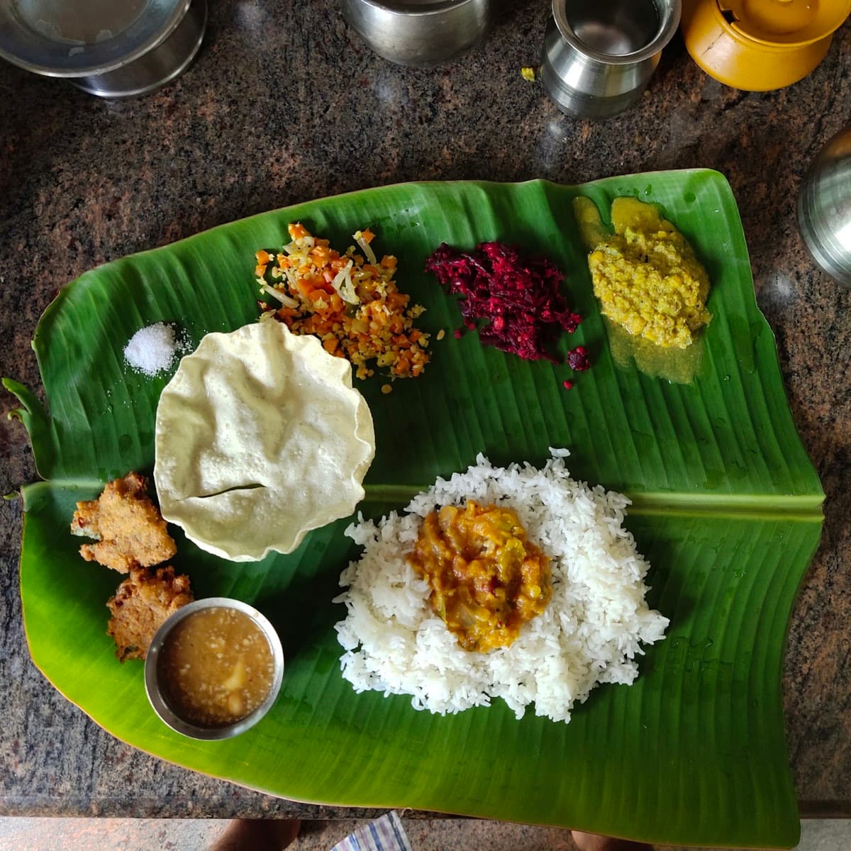 Andhra meal being served course by course on a fresh banana leaf